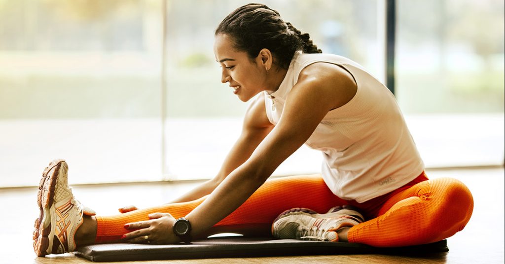 runner stretching on mat on floor